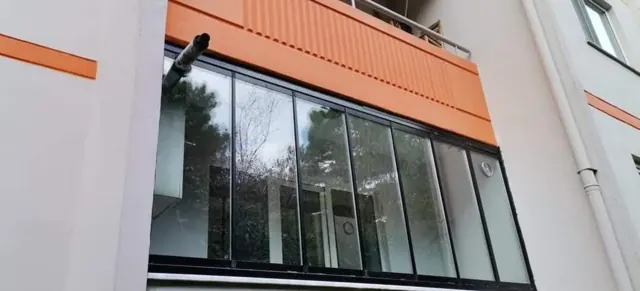 Bina cephesinde siyah çerçeveli cam balkon